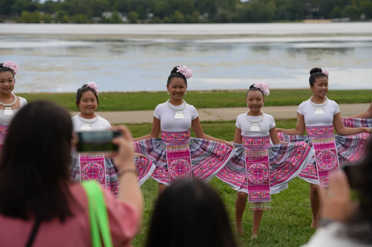 A line of young dancers in pink costumes performing on the lawn