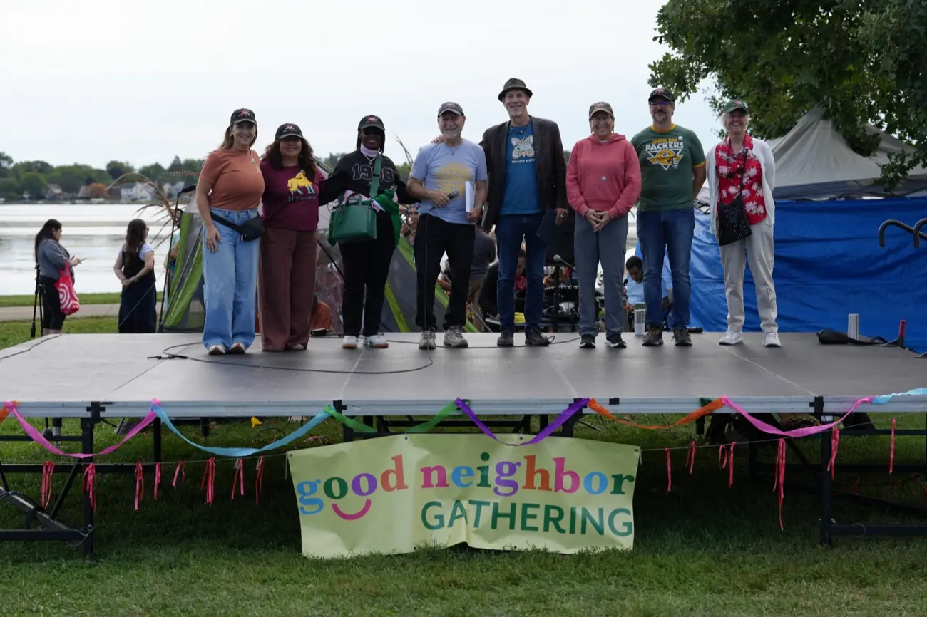 Performers gathered on stage in front of the Good Neighbor Gathering banner